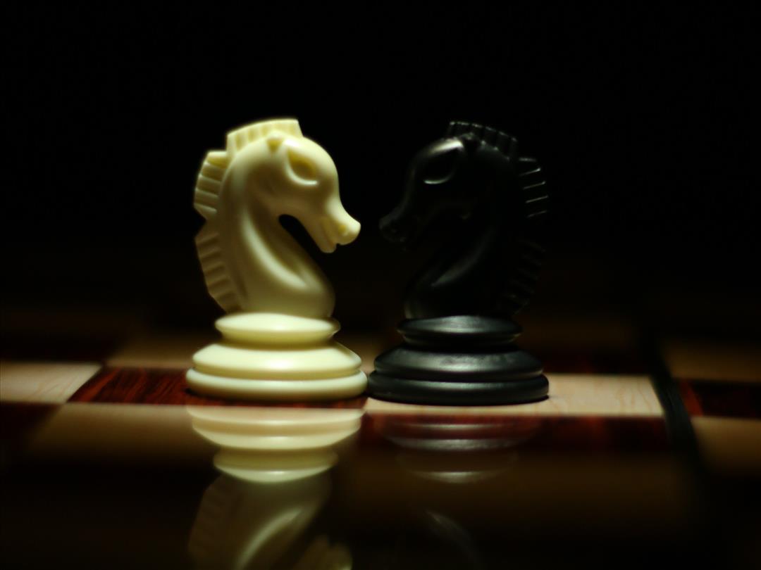 Two chess pieces facing each other on a board