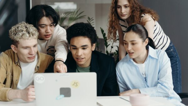 Employees huddled around a laptop