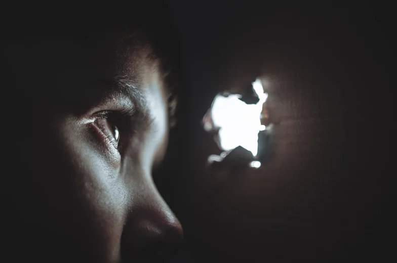 Boy peaking through hole